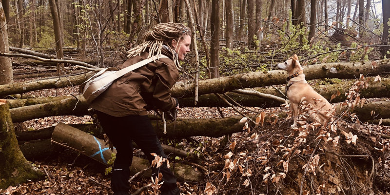 Christine LU Surma mit einem Hund im Wald